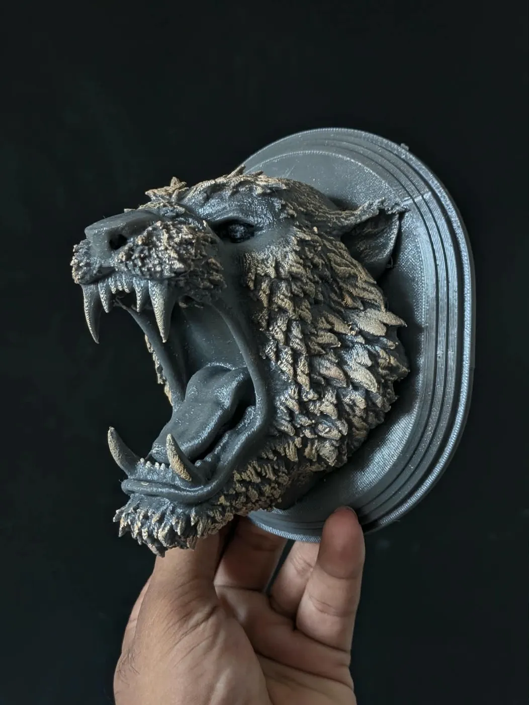 3D printed snarling wolf head wall mount held in hand